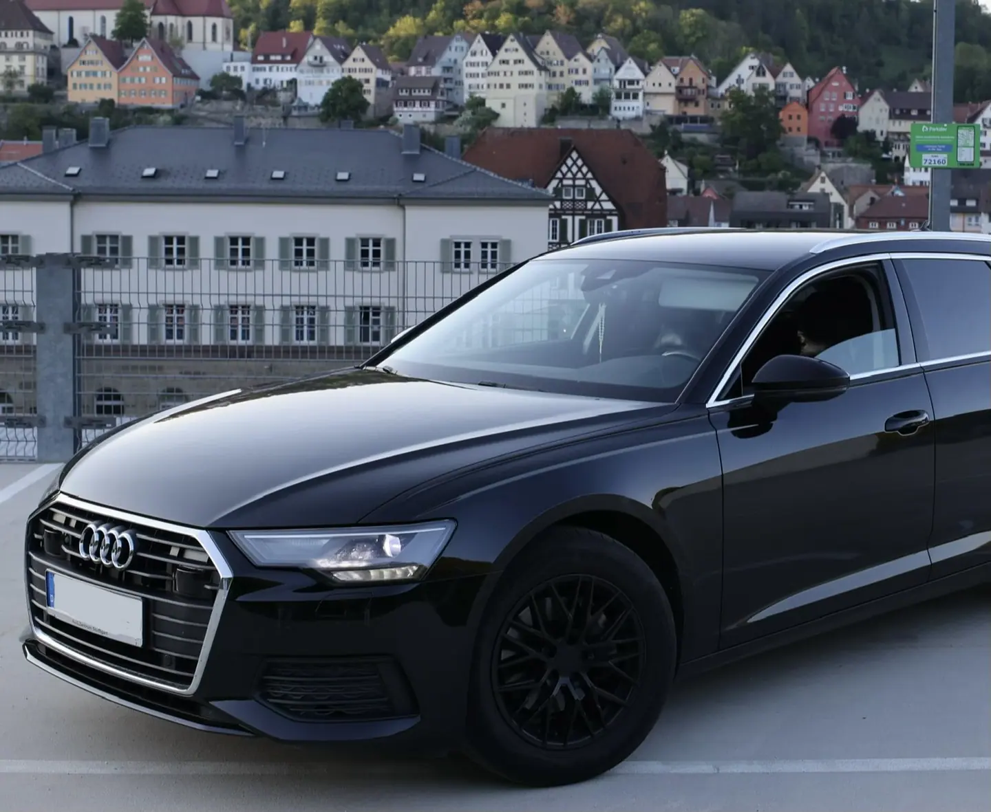 Audi Limousine mit Chauffeur auf einem Dachparkplatz mit Blick über die Stadt