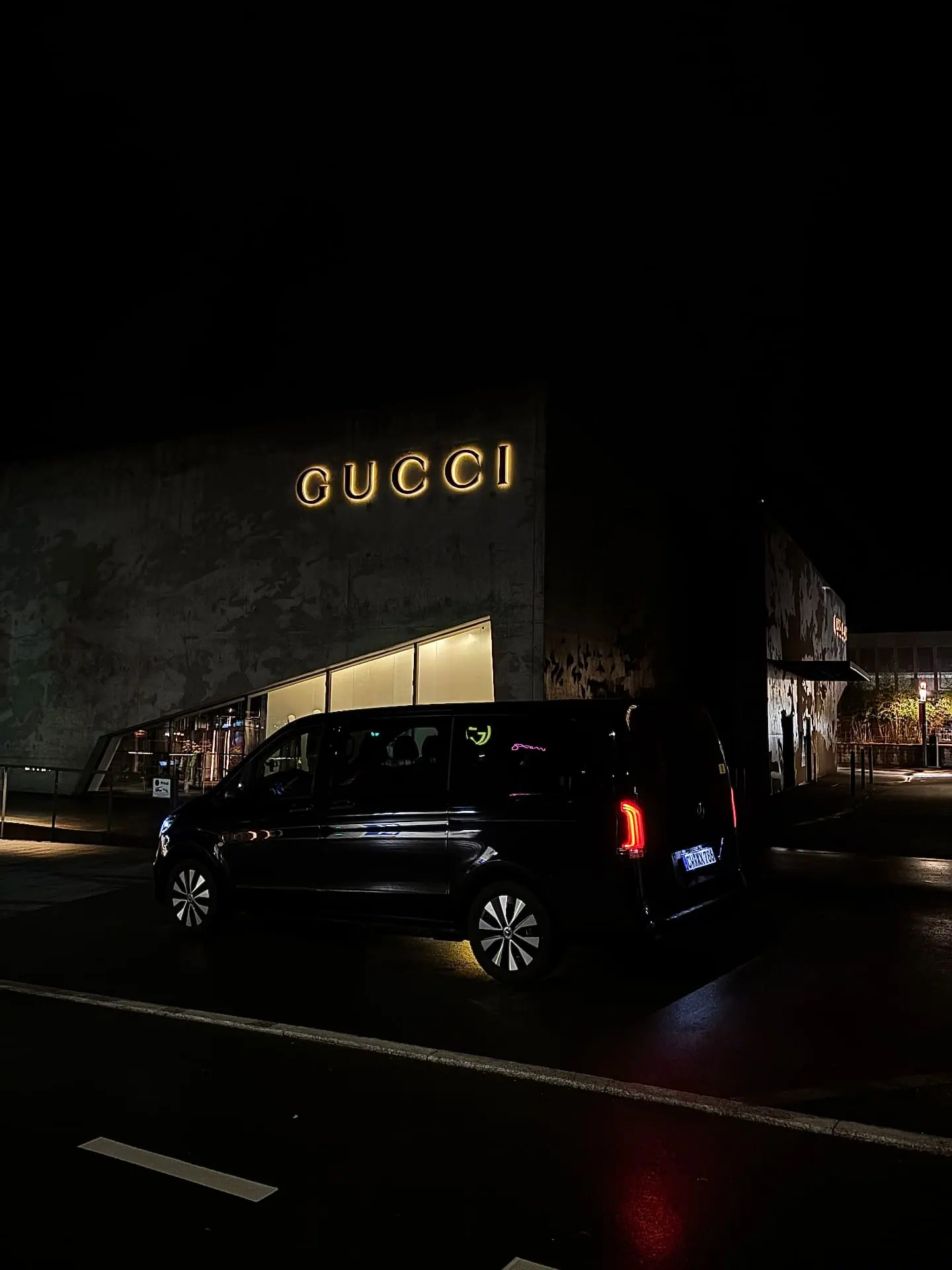 Mercedes V-Class chauffeur outside the Gucci store at Outletcity Metzingen at night