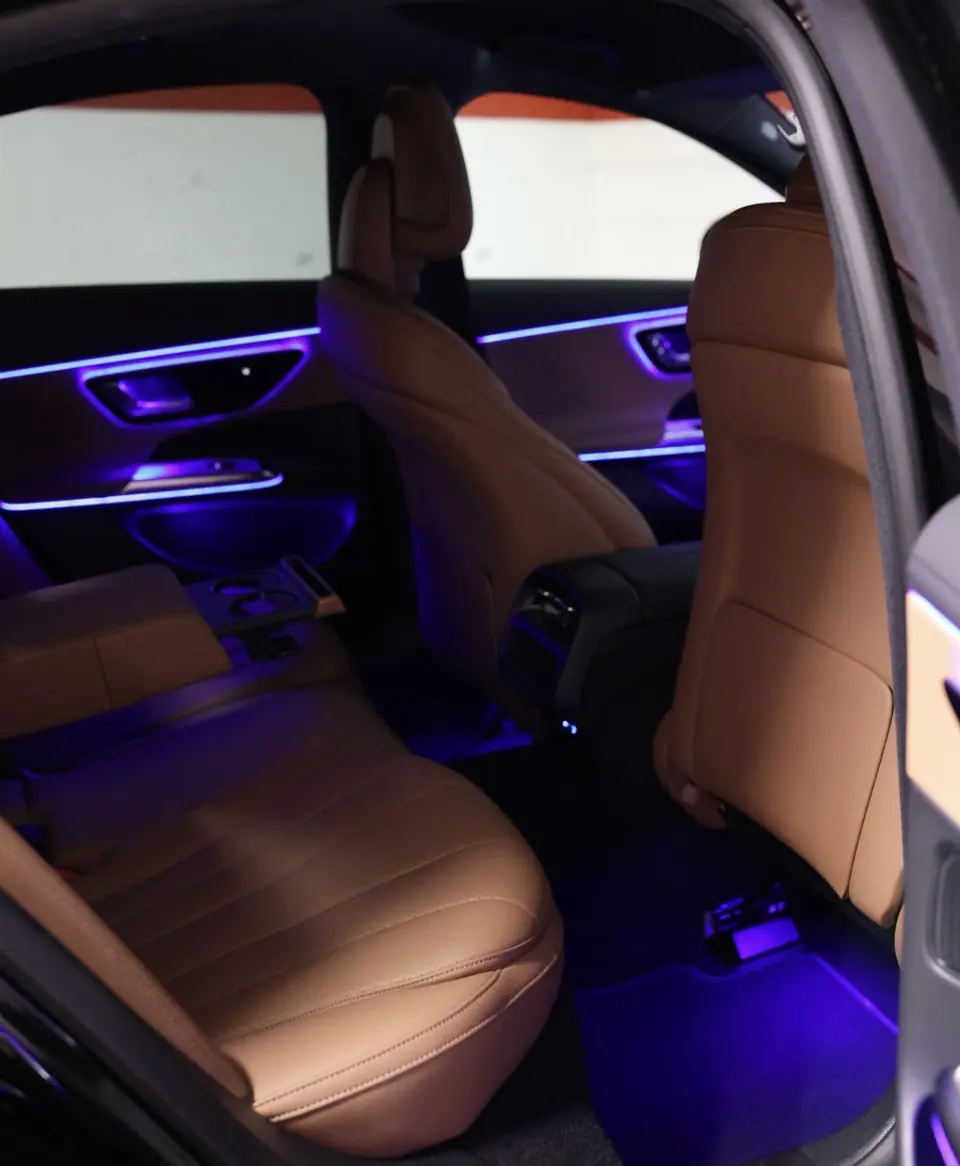 Fond der Mercedes E-Klasse mit braunem Leder und violetter Ambiente-Beleuchtung — Chauffeurservice Stuttgart