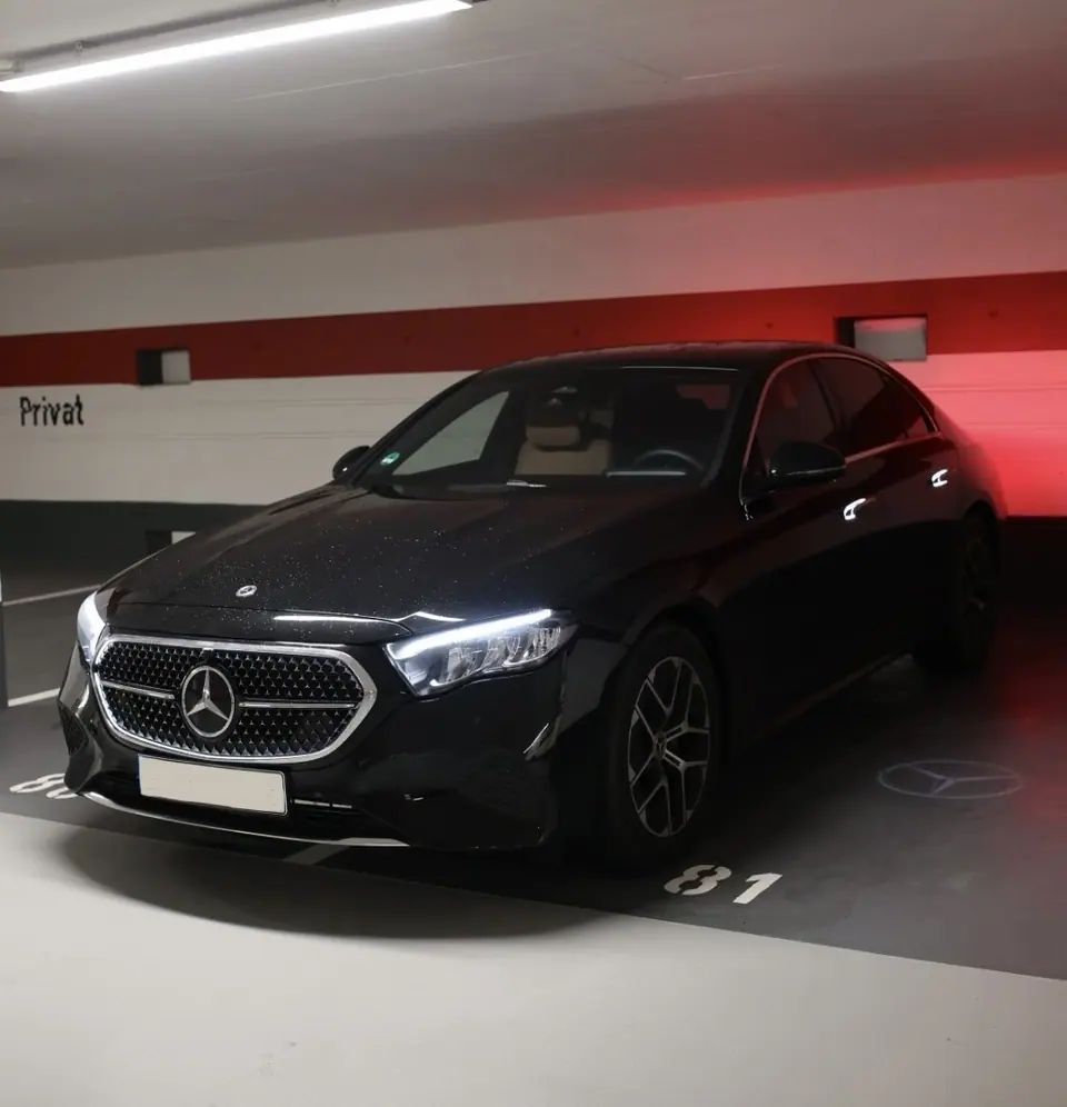 Schwarze Mercedes E-Klasse in einer Tiefgarage, Frontansicht mit Stern auf den Boden projiziert
