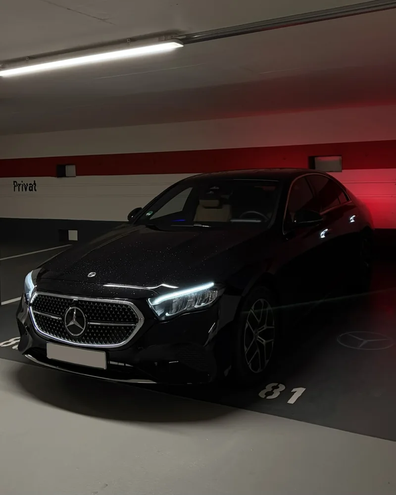 Schwarze Mercedes E-Klasse im Parkhaus mit projiziertem Stern — Chauffeurservice Stuttgart
