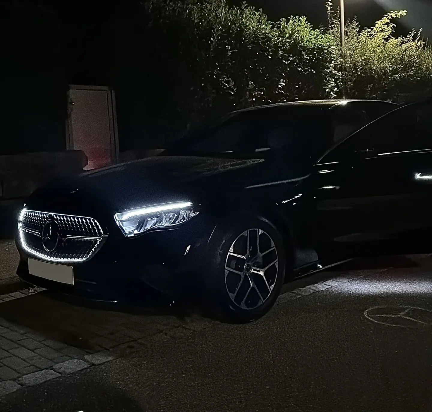 Schwarze Mercedes Limousine bei Nacht mit geöffneter Tür und auf den Asphalt projiziertem Stern — Flughafentransfer Stuttgart