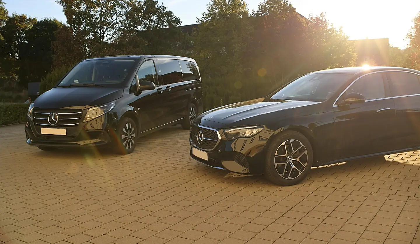 Schwarze Mercedes V-Klasse und E-Klasse auf einem Hotelparkplatz im warmen Abendlicht — Chauffeurservice und Limousinenservice Stuttgart